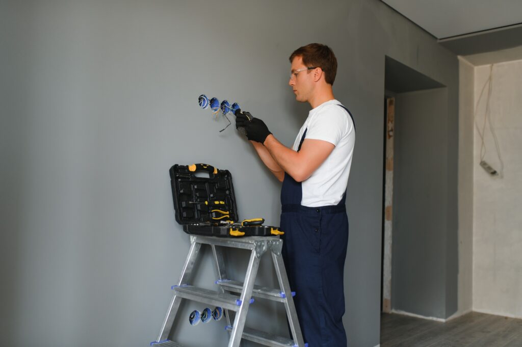 Electrician Builder at work, installation of sockets and switches.